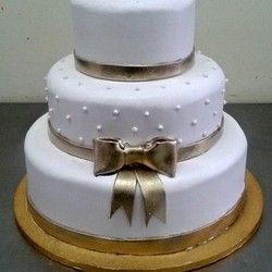 Svadbena torta bela sa zlatnom mašnom